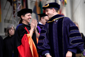 photo of Professor applauding a PhD student at commencement